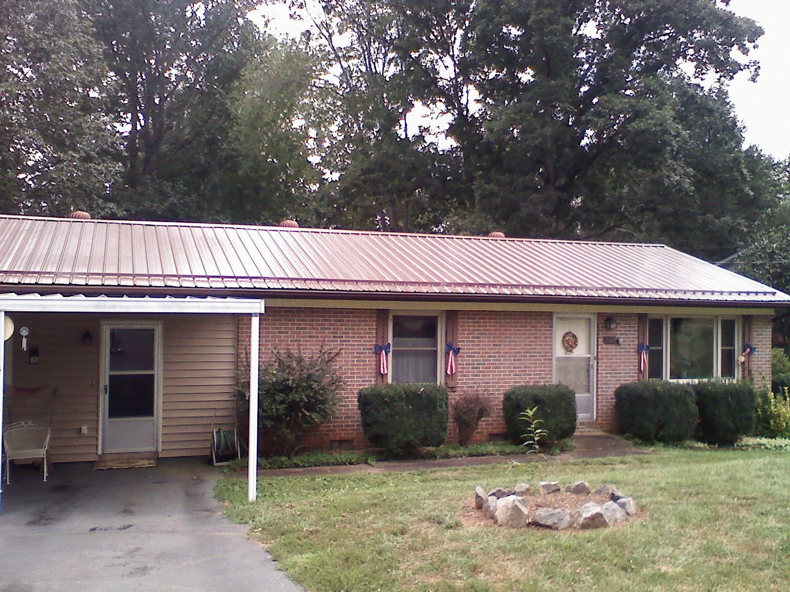 Bronze metal roof and carport on a brick ranch home — Roof Repair work by our crew in Port Huron