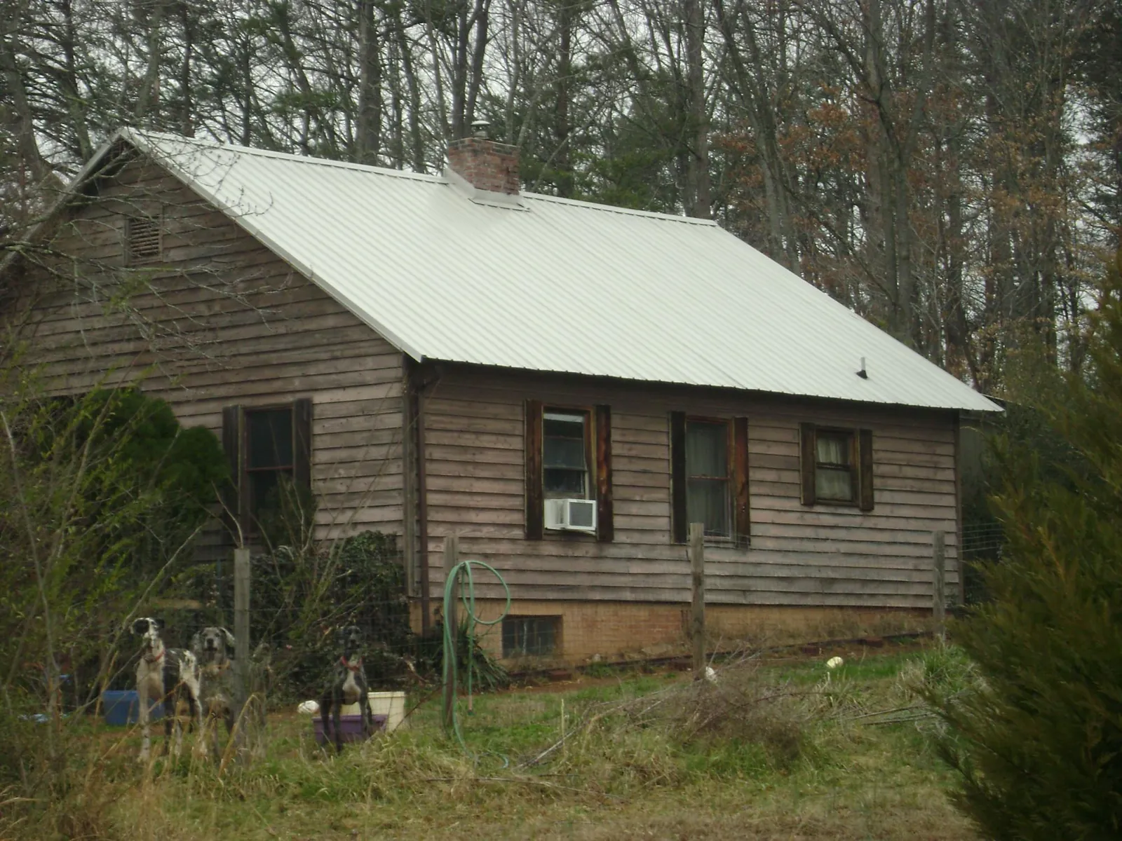 White metal roof on an old wood sided farmhouse, from a Metal Roof Installation job in Port Huron